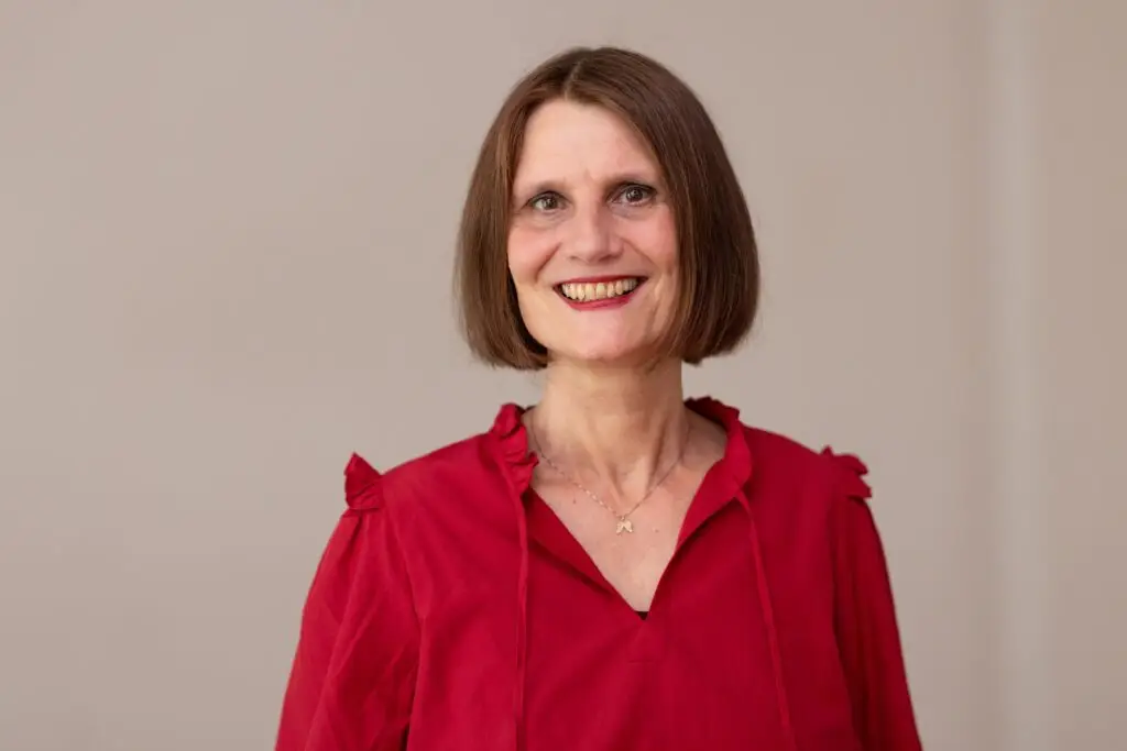 Lächelnde Frau in roter Bluse.